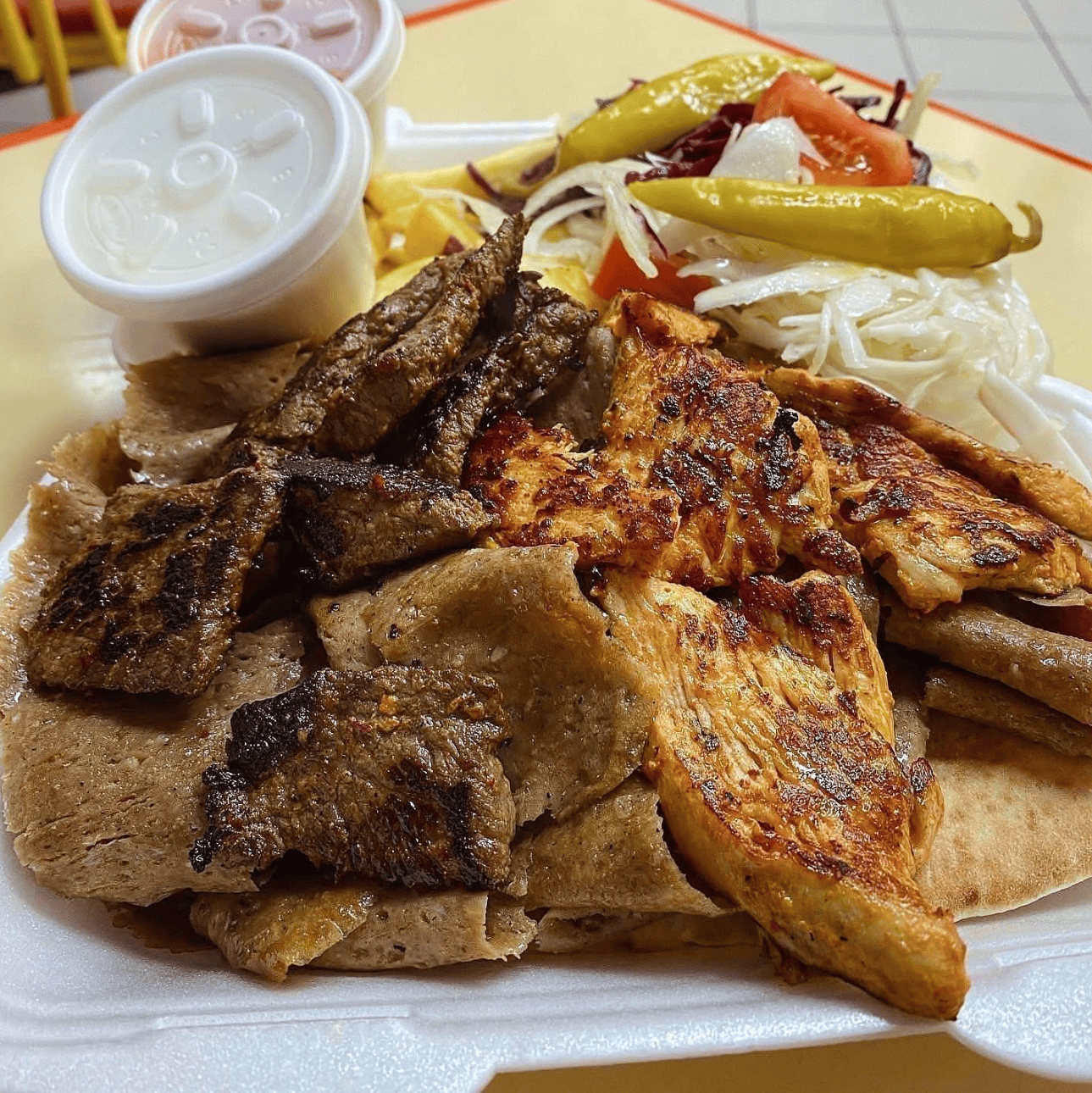 Get Stuffed’s mixed kebabs meal with slices of dark meat, grilled chicken, salad, peppers, and  sauce.